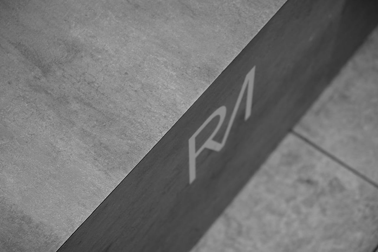 Grayscale Photo of Initials On Concrete Surface